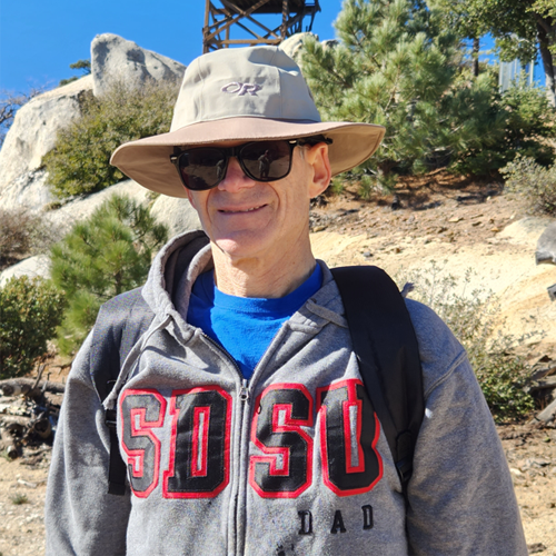 man hiking wearing hat and SDSU sweatshirt