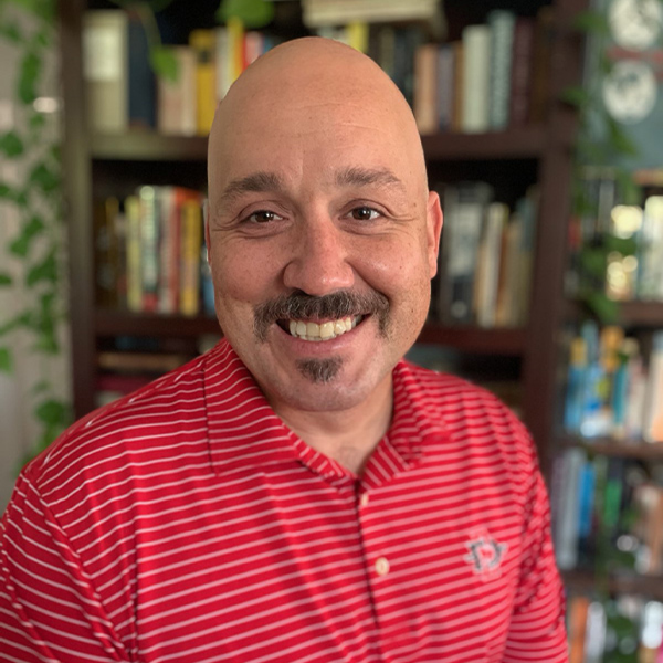smiling man with mustache and shaved head