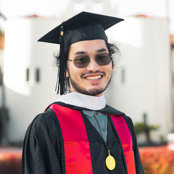 man smiling wearing cap, gown and glasses