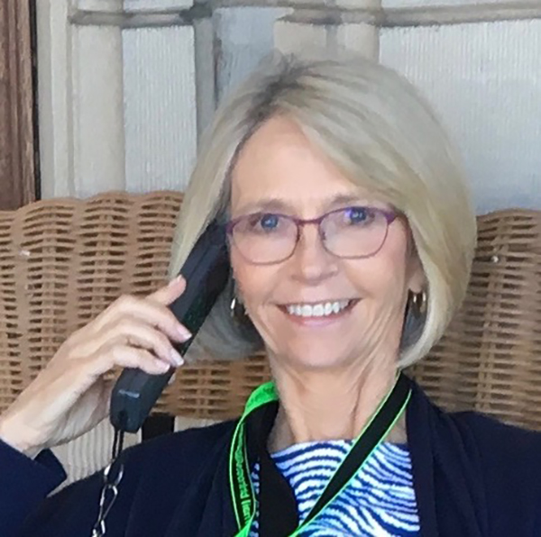 woman smiling wearing glasses and talking on the phone