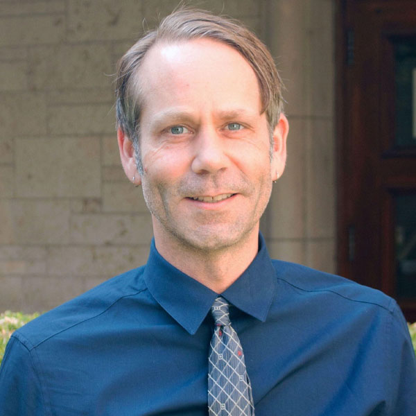 man wearing tie and smiling